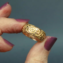 Load image into Gallery viewer, Antique Edwardian era wide gold stacking band ring in 9ct gold. Antique wedding ring with pansy and ivy leaf design around circumference. Ivy leaf symbolising fidelity, loyalty, devotion. Pansies for loving thoughts. Anniversary gift ring.