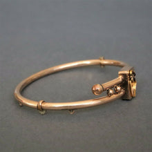 Load image into Gallery viewer, Antique Victorian era bypass bangle with garnets in 10ct gold casing