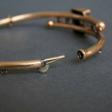 Load image into Gallery viewer, Antique Victorian era bypass bangle with garnets in 10ct gold casing