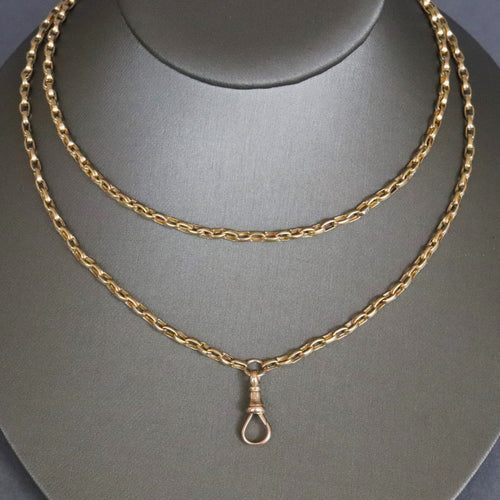 Antique Victorian long guard chain in 9ct 9k yellow gold with oval belcher links and dog clip.
