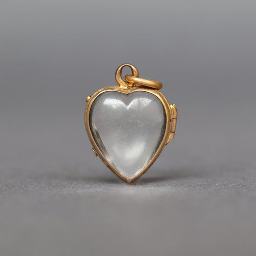antique glass puffy heart locket dating Victorian era. Two glass leaves held in a hinged bracket with yellow gold gilding. It opens to allow flat items (photos, pressed flowers) to be placed inside.