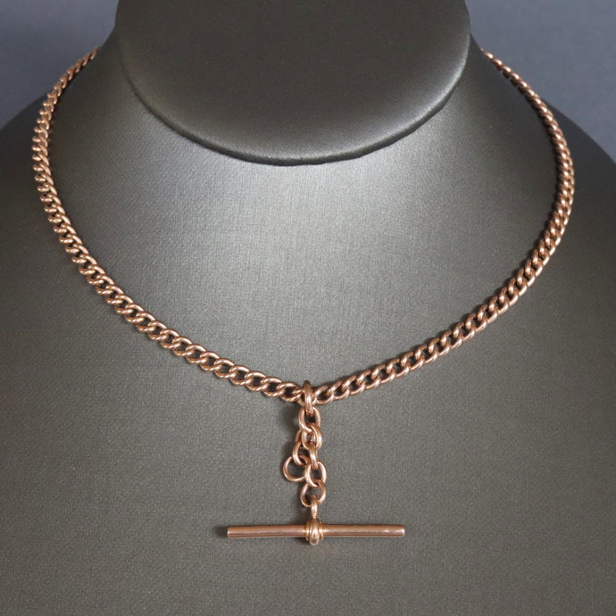 Albert chain. Watch chain. Gold watch chain. Curb link chain. Double dog clips. Dog clip chain. Floating fob. Chain with floating fob. Gold chain. Gold watch chain. Gold curb link chain. 9k gold chain. 9ct gold chain. Antique Albert watch chain with floating T-bar fob, double dog clips in 9ct rose gold. Short length antique chain. Choker length chain.