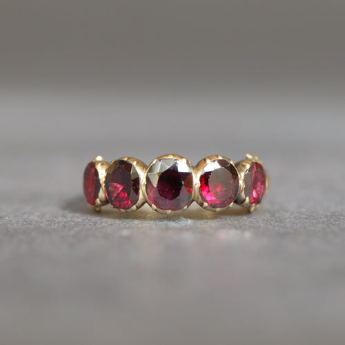 Antique Georgian flat cut garnet ring in 14ct yellow gold with engraved split shoulders. Oval garnets in a five stone half-hoop band. Foil-backed garnets. Foiled garnet ring.