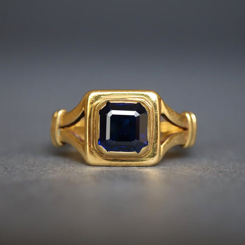 Antique early vintage square cut sapphire ring in an 18ct yellow gold band with split shoulders.