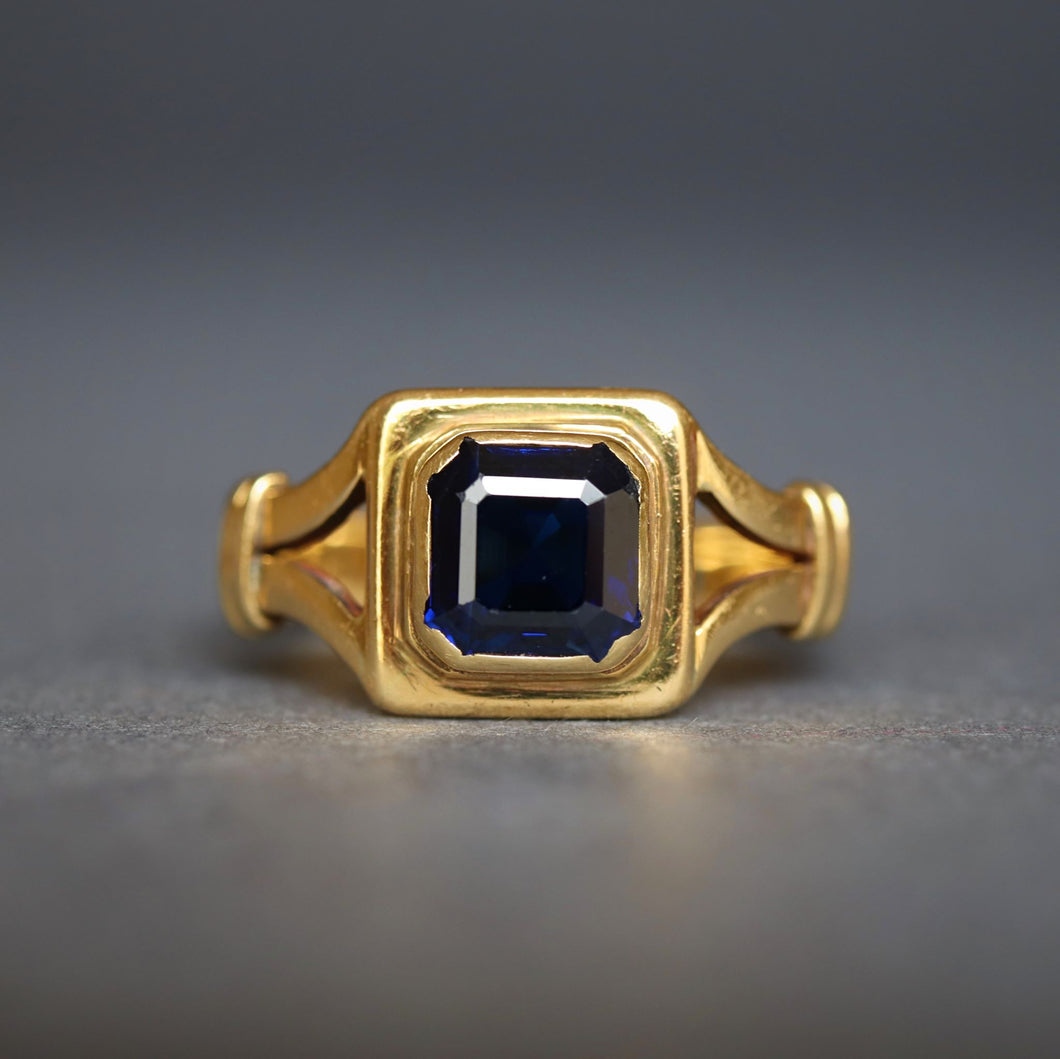 Antique early vintage square cut sapphire ring in an 18ct yellow gold band with split shoulders.
