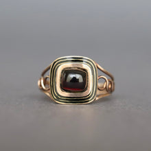 Load image into Gallery viewer, A rectangular antique Georgian mourning memorial ring featuring a dark red garnet cabochon cut in a gold setting with concentric gold bands.
