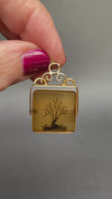 Load and play video in Gallery viewer, Vintage mid-century spinner pendant set with brown dendritic agate in a vermeil frame.
