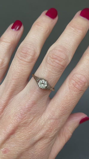 Antique diamond solitaire ring. Prong setting. Openwork gallery. Platinum and gold band. Cathedral. Round early brilliant cut. Antique engagement ring.